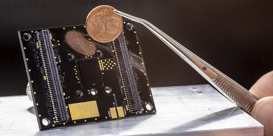 Sensor in the foreground a tweezers with one cent coin