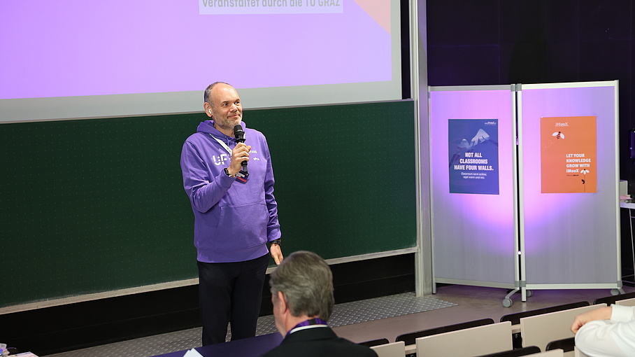 Person standing in a lecture hall and giving a speech