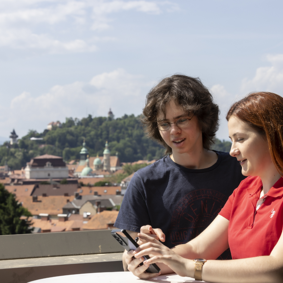 Zwei Studierende, Schlossberg im Hintergrund