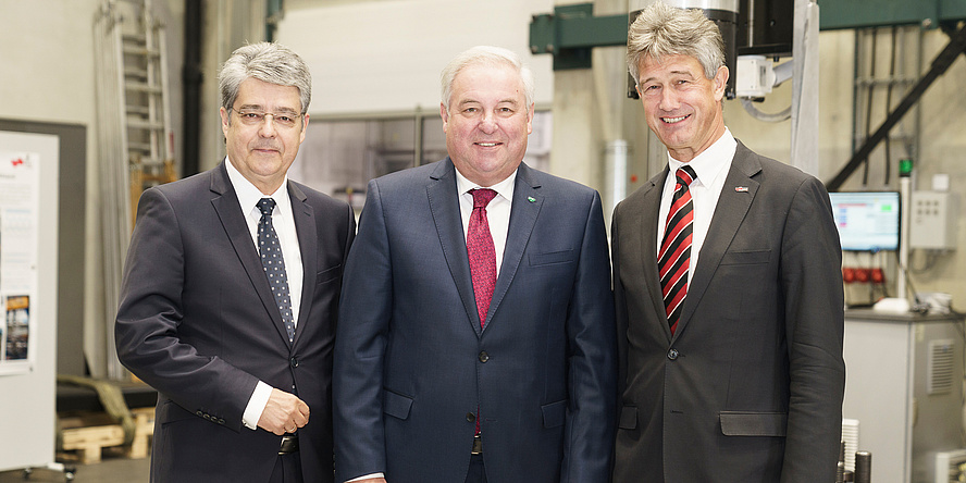 Siemens Austria CEO Wolfgang Hesoun, state governor Hermann Schützenhöfer and TU Graz Rector Harald Kainz are standing in a row. In the background, you can see the structural durability laboratory ‘Fatigue Testing Laboratory’