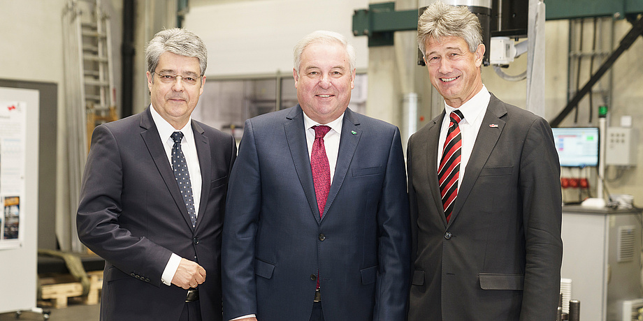Siemens Austria CEO Wolfgang Hesoun, state governor Hermann Schützenhöfer and TU Graz Rector Harald Kainz are standing in a row. In the background, you can see the structural durability laboratory ‘Fatigue Testing Laboratory’