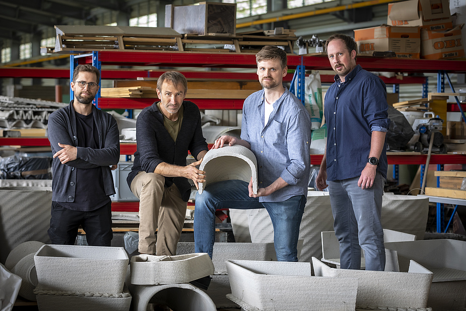 Four men with different objects made of concrete
