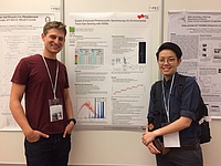 Philipp Breitegger and another conference participant standing in front of a conference poster.