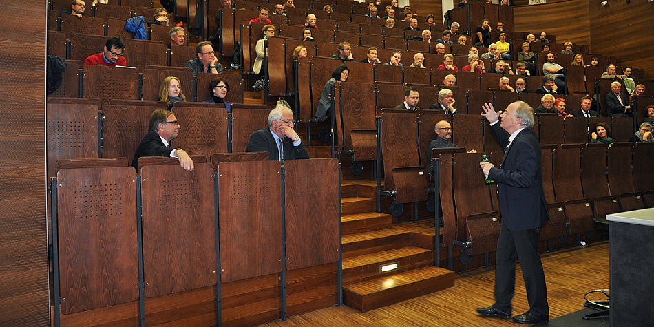 A man is standing in front of an auditorium.