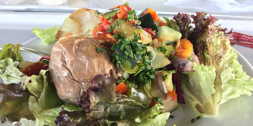 Jacket potato served on a colourful mixed salad.