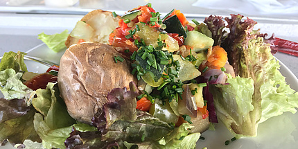 Jacket potato served on a colourful mixed salad.