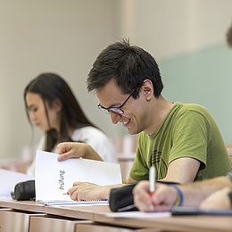 Studierende arbeiten konzentriert während einer schriftlichen Prüfung.