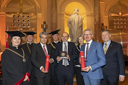 Menschengruppe in Festkleidung und Talar