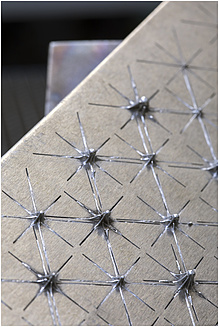 Detail of a metal surface with star-like relief.