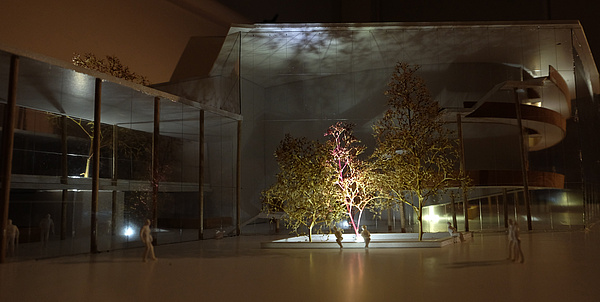 Architekturmodell eines Hauses, davor steht eine Baumgruppe - das Ensemble wir lichttechnisch bespielt.