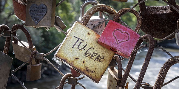 BColorful locks on a bridge, one of them with the inscription "TU Graz".