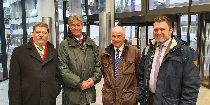 Four men in an entrance hall