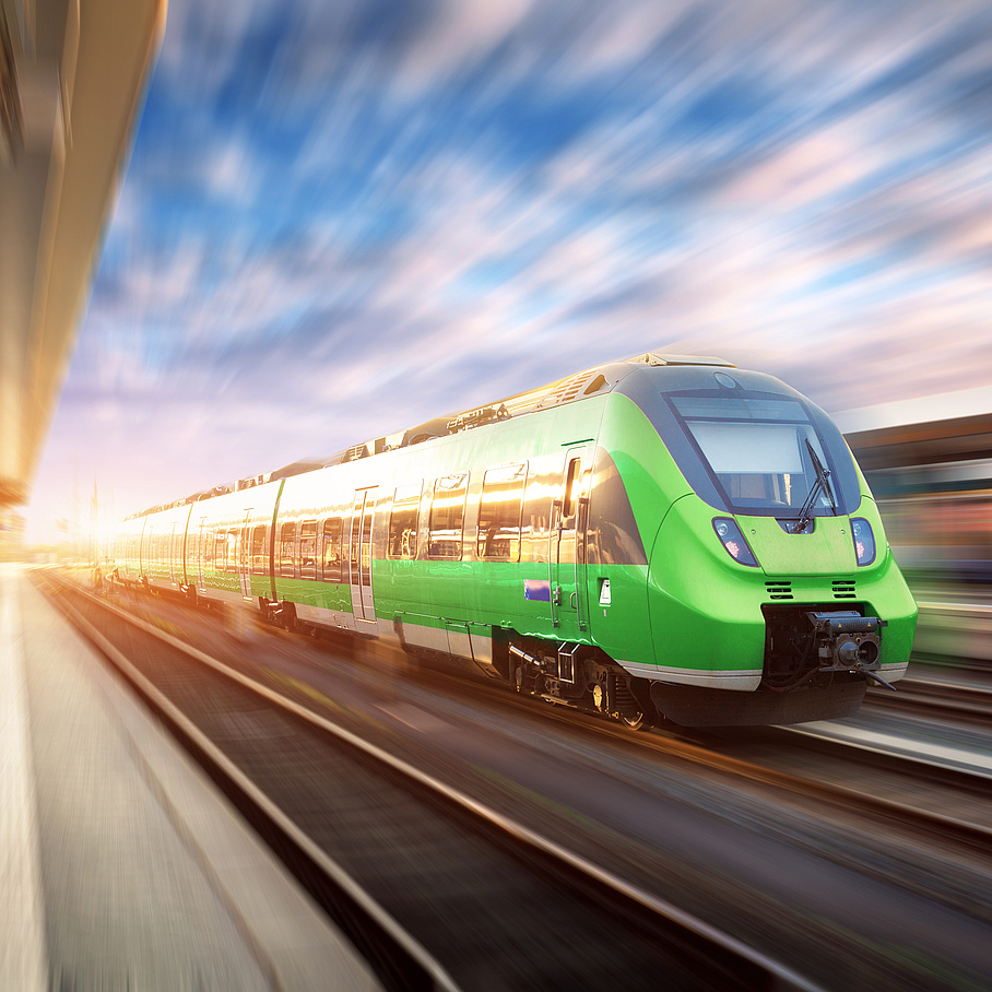 Grüner Zug fährt mit hoher Geschwindigkeit