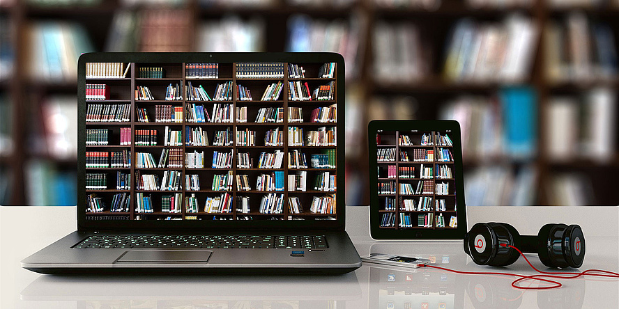 Laptop und E-Book-Reader mit einem Bild von Bücherregalen am Screen