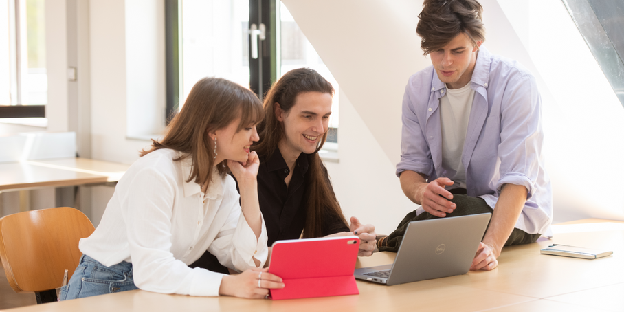3 people with a tablet and laptop.