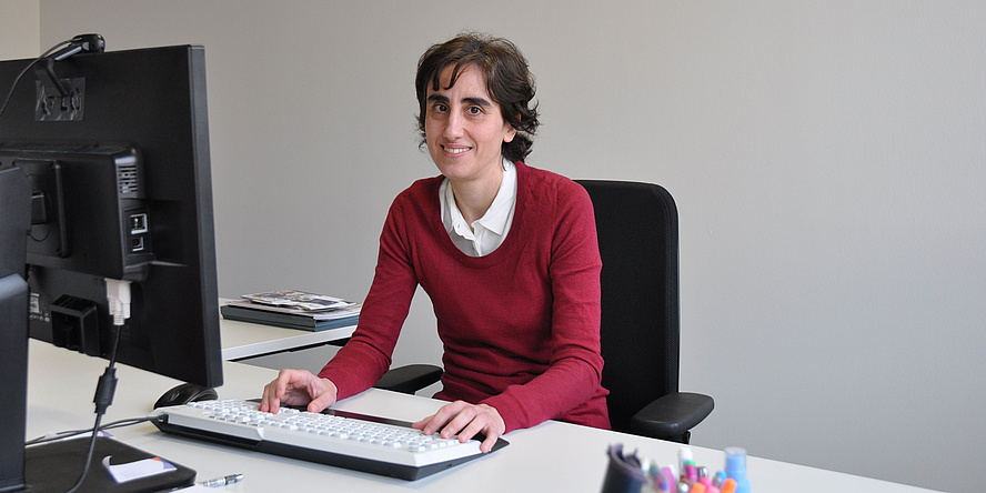 Young woman working at a computer station.