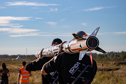 ISPIDA on its way to the launch pad. Image source: ASTG Two people are carrying a rocket on their shoulders.