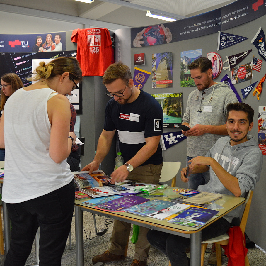 students standing at a booth and providing information about study abroad opportunities