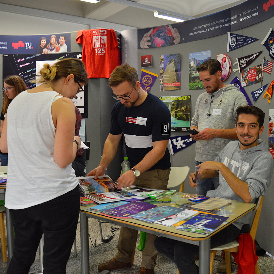 students standing at a booth and providing information about study abroad opportunities