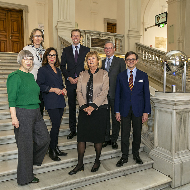 Seven people are standing on stairs.