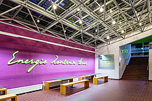 Blick ins Foyer eines Gebäudes mit der Wandaufschrift "Energie Zentrum Graz". 
