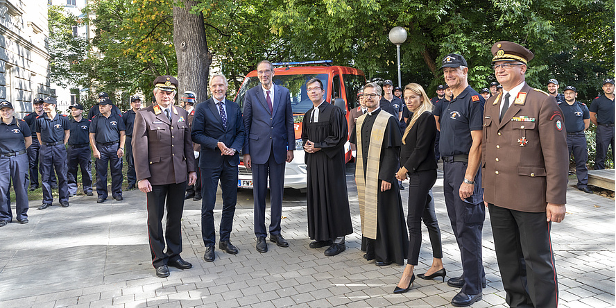 Sieben Männer und eine Frau vor dem Feuerwehrbus der Freiwilligen Feuerwehr der TU Graz.