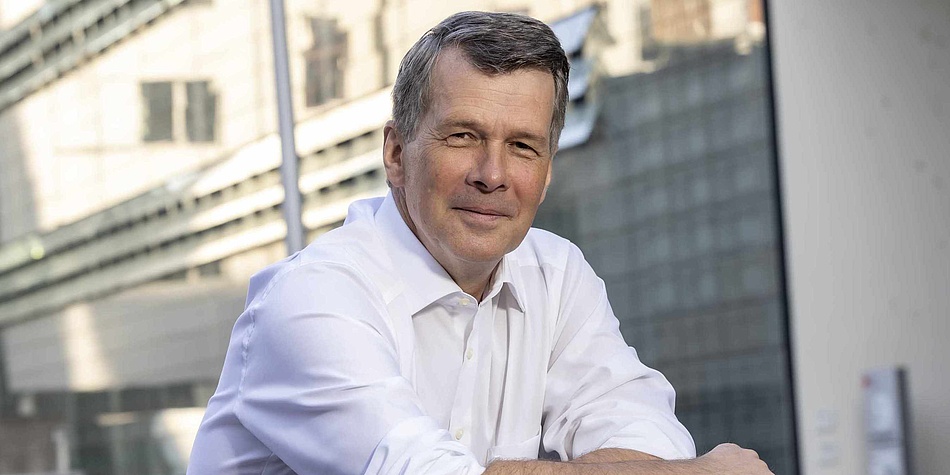 Mann im weißen Hemd blickt in die Kamera. 