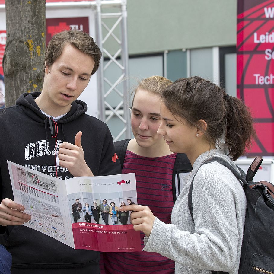 Schülerinnen werden von einem jungen Mann beraten.