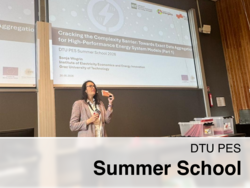 Eine Frau hält einen Vortrag bei der „DTU PES Summer School 2026“ vor einer Projektionsfolie mit dem Titel *„Cracking the Complexity Barrier: Towards Exact Data Aggregation for High-Performance Energy System Models (Part 1)“.