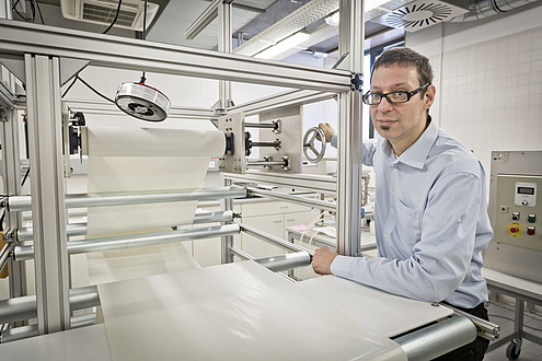 Man beside big paper machine