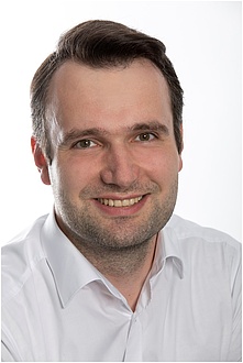 A man smiles into the camera.