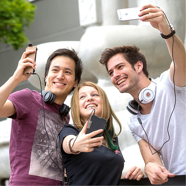 Two men and a woman with mobile phones and headsets. Photo source: Lunghammer - TU Graz