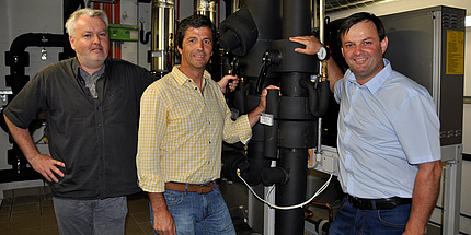 Gernot Prem, Horst Gangl and Siegfried Pabst standing next to the cooling system.