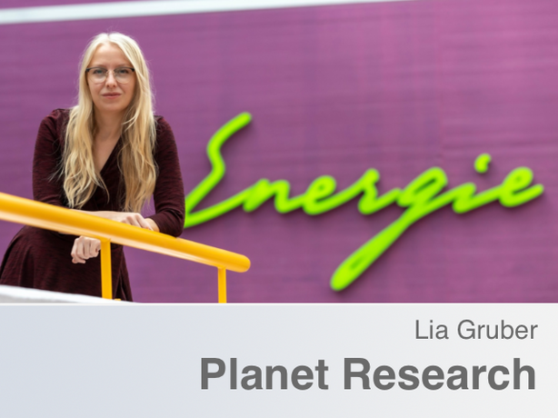 Lia Gruber im Vordergrund. Im Hintergrund eine grüner Schriftzug "Energie" auf einer violetten Wand.