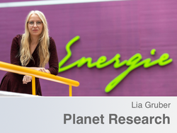 Lia Gruber in front of a purple wall with a green "Energy" slogan. 