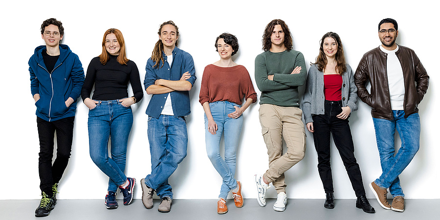 7 young people in front of a white background.