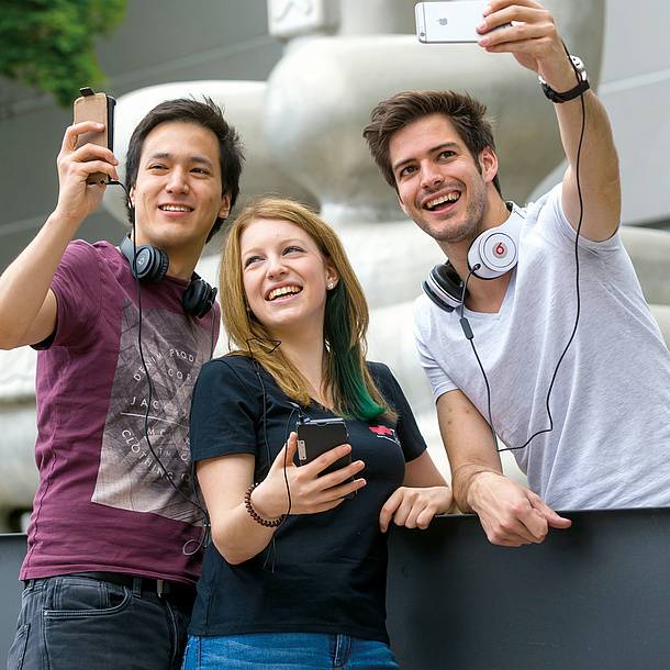 Two men and a woman wearing headsets and using their mobile phones. Photo source: Lunghammer - TU Graz