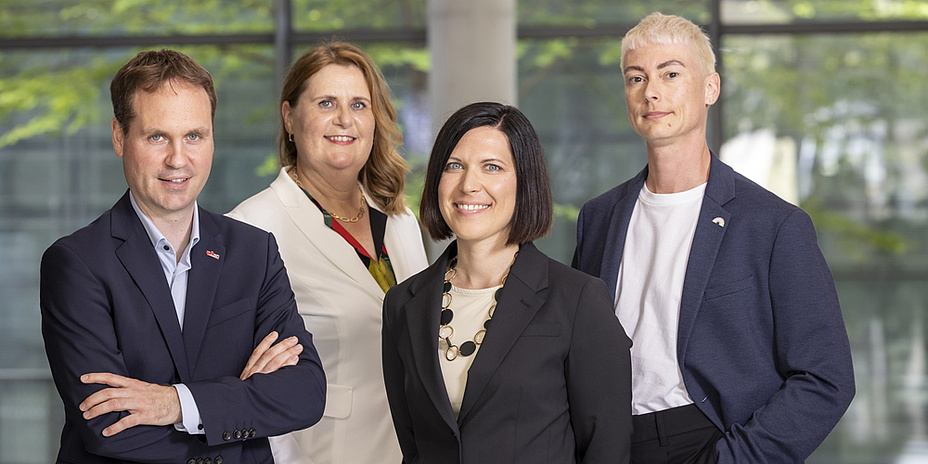 The four team members of the Sustainability Unit smile into the camera.