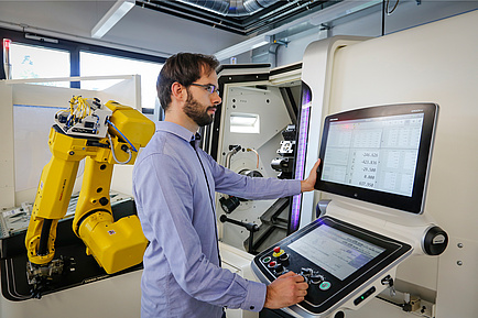 TU Graz researcher operates a CNC turning, milling and gear cutting centre