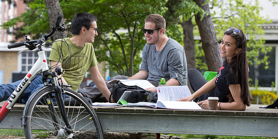 Students learning together in the outdoor area of the Neue Technik Campus of TU Graz.