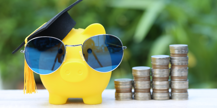 Sparschwein mit Sonnenbrille und Münzstapel