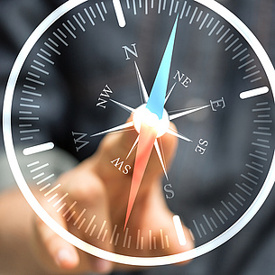 Eine Hand zeigt auf einen Kompass aus Glas. Bildquelle: vege – Fotolia.com