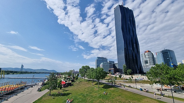 A picture of a large black office building next to a river