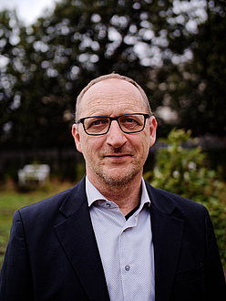 Portrait of a man with glasses and suit