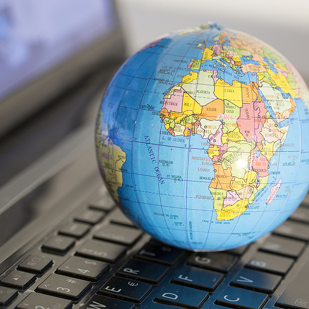 Small globe lying on the keyboard of a note book. Photo source: aytuncolym - Fotolia.com