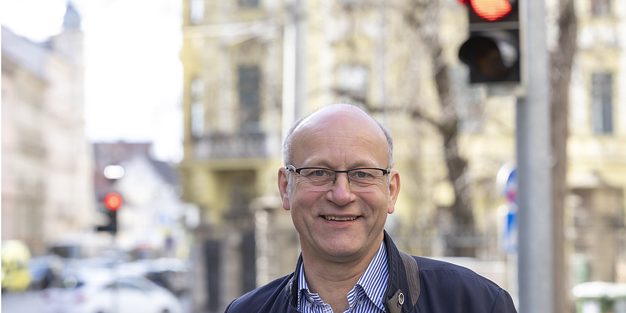 Lächelnder Mann vor einer Verkehrsampel