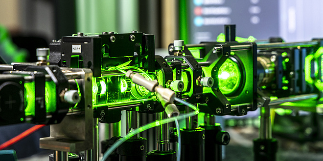 Ein grüner Laser, der durch mehrere Linsen geleitet wird.