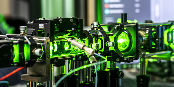 Ein grüner Laser, der durch mehrere Linsen geleitet wird.
