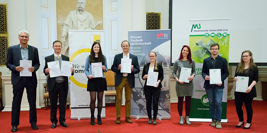 Gruppe an Forschenden mit Urkunden in der Hand