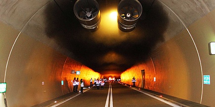 Einblick in der Innere einer Tunnelanlage mit Flammen, Rauch und Lüftungsanlage.